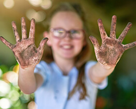 Young girl showing dirty palms to the camera